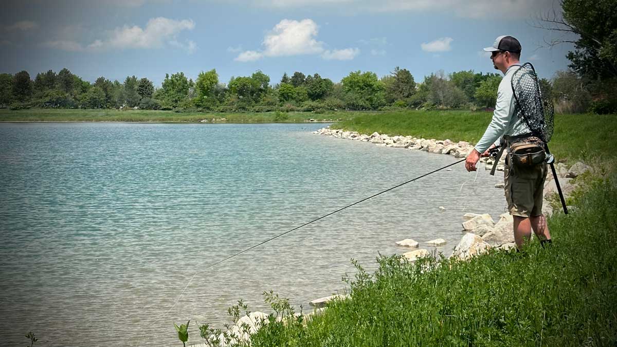 Man fly fishing on lake for large trout
